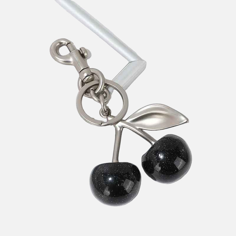 Silver keychain with black cherry-like charms on a white background