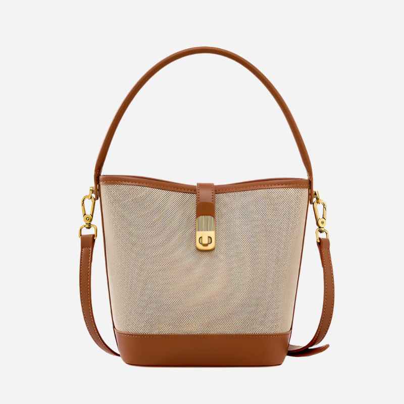 Bucket bag with beige fabric and brown leather accents on a white background