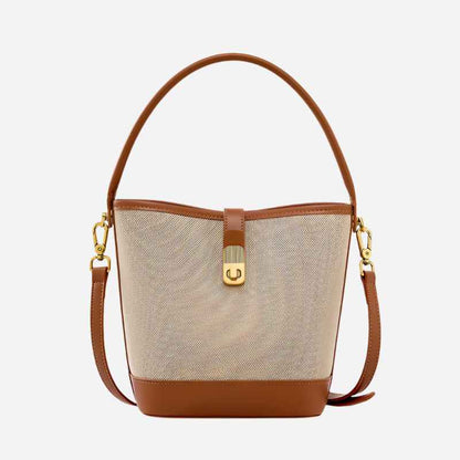 Bucket bag with beige fabric and brown leather accents on a white background