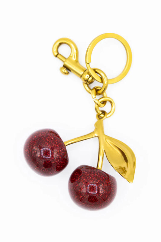 Gold keychain with red cherries on a white background